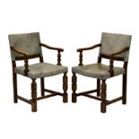 A pair of carved oak 17th century style dining chairs, early 20th century, the rectangular backs and