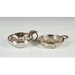 Two silver plated tastevins, the first with foliate decoration and serpent ring handle by J. E & S