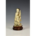 A Japanese carved ivory okimono, Meiji period (1868-1912), of an elegant lady seated upon