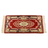 An Eastern Kayam OCM wool rug, 20th century, on red ground and guard border with floral main