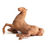 A TERRACOTTA FIGURE OF A RECUMBENT HORSE, PROBABLY ITALIAN, 20TH CENTURY