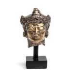 A PARCEL GILT SHEET SILVER HEAD OF A DEITY, JAVA, CIRCA 18TH CENTURY