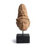 A SMALL BUFF SANDSTONE HEAD OF A DEITY, PROBABLY SIVA, CENTRAL INDIA, 11TH/12TH CENTURY