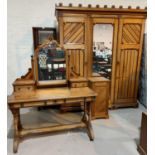 A late 19th century Arts & Crafts bedroom suite in pitch pine, comprising triple wardrobe with