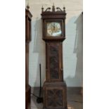 An 18th century oak longcase clock with later carved decoration, having fretted swan neck