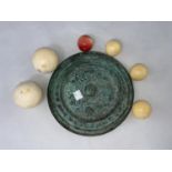 Two large ivory billiard balls and 4 smaller balls and a Chinese bronze mirror