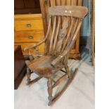 A stained wood rocking chair with lath back