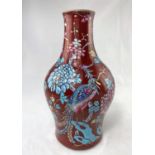 A Chinese stoneware vase with deep red flambé style glaze and polychrome birds and chrysanthemums