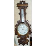 An Edwardian barometer with thermometer in floral carved banjo shaped case, by Ward & Brown,