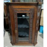 A 19th century carved oak corner cupboard enclosed by glazed door, height 92 cm