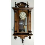 A 19th century Vienna wall clock in walnut case with turned finials and Arts & Crafts design stained