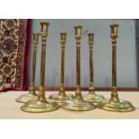 Three early 19th century pairs of brass candlesticks of tall slender form