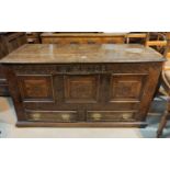 An early 18th century oak mule chest, with later carved decoration, hinged plank top, triple fielded