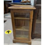 An Ercol small cabinet with glazed door and small shelves to side