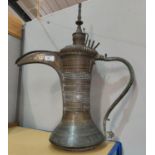 A Middle Eastern brass coffee pot of waisted form, with extensive pierced and engraved decoration,