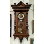 A 19th century Vienna wall clock in walnut case with architectural pediment and half turned side