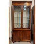 A Georgian style crossbanded mahogany full height bookcase with twin glazed doors over double