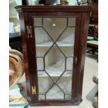 A 19th century mahogany corner cupboard with straight front, enclosed by astragal glazed door