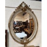 A large Georgian style wall mirror in gilt metal and marble effect ornate oval frame