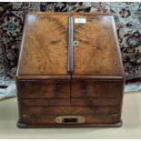 A Victorian walnut stationery cabinet with slope front, slide-out writing surface, inset brass