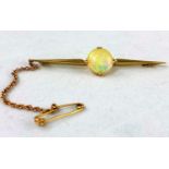 A yellow metal bar brooch set circular domed opal, diameter 10 mm, inscribed '832', 4 gm, tests as