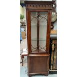 A reproduction full length corner display cabinet in mahogany, with glazed and panelled doors, on