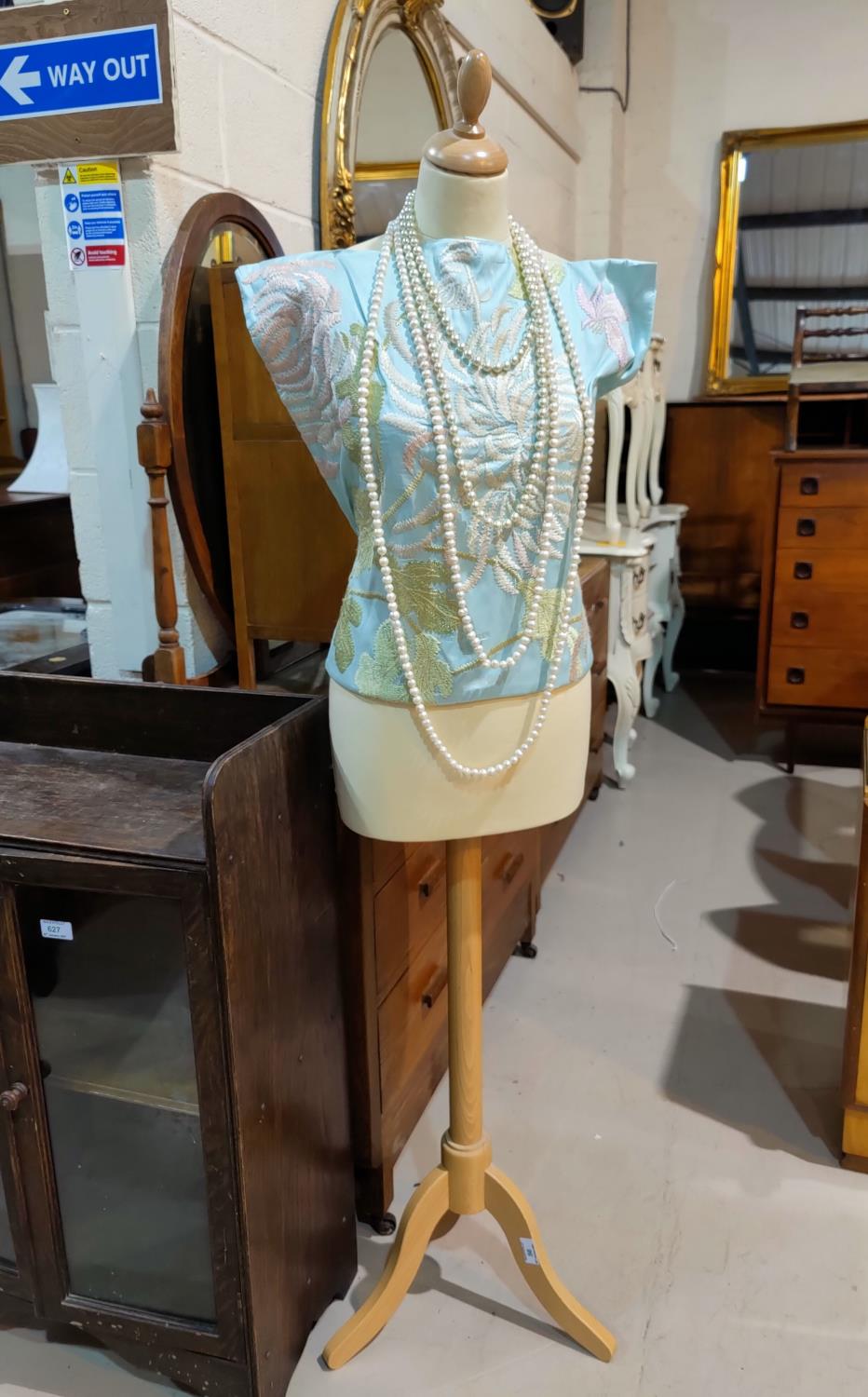 A tailor's dummy with bead and floral decoration