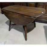 An Ercol dark elm drop leaf dining table