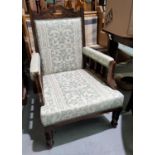 An Edwardian armchair with carved frame, reupholstered in cream/green patterned fabric