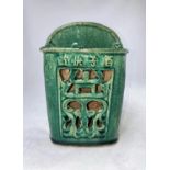 A Chinese glazed stoneware wall pocket in green with pierced decoration, height 18.5cm