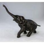 A Japanese Meiji period bronze elephant with outstretched trunk, rectangular seal mark to