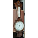 An Edwardian carved oak aneroid barometer with long thermometer box