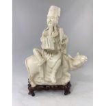 A Chinese blanc de chine group, man sat on cow, on wooden stand, full height 33cm (cow head a.f.)