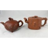 Two Yixing tea pots both with seal marks, 1 with character mark decoration, 1 with relief decoration
