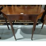 An Edwardian mahogany card table, with canted fold-over top and baize lining, on square tapering