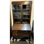 A 1930's oak bureau bookcase with twin glazed doors over fall front and 3 drawers, cabriole legs (