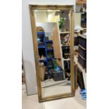 A full length wall mirror in rectangular gilt frame; an oval wall mirror
