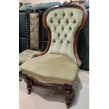 A Victorian mahogany nursing chair with spoon back and carved decoration, on turned legs, fawn