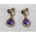 A pair of yellow metal earrings test 14ct comprising of an amethyst with larger round amethyst in
