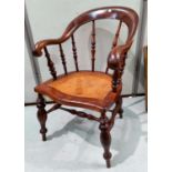 A 19th century smokers bow armchair with bergère seat, on turned legs