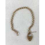 A curb chain bracelet with heart fob, stamped '375', 7 gm