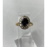 A lady's dress ring set central sapphire and 12 diamond surround, yellow metal shank stamped '18ct',