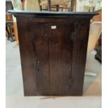 An 18th century country made wall hanging cupboard enclosed by single door, height 88 cm