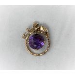 A yellow metal pendant with large round amethyst in swinging circular mount (to match earrings in