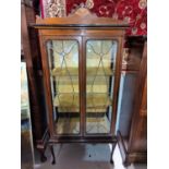 An Edwardian inlaid mahogany china cabinet in the Sheraton style, with arched crest and leaded