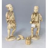 A pair of early 20th century Japanese sectional ivory figures with baskets on their backs, one