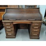 An early 20th century oak kneehole desk with 'S' shaped roll top