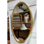 A large bevelled wall mirror in oval gilt frame, length 123 cm; a full length wall mirror in