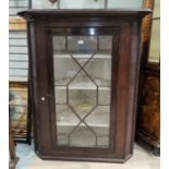 A late Georgian oak corner cupboard, single astragel glazed door enclosing three shelves, 94cm wide,