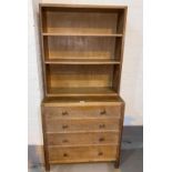 A 1930's limed oak 4 height chest of drawers with bookcase top, by Heals